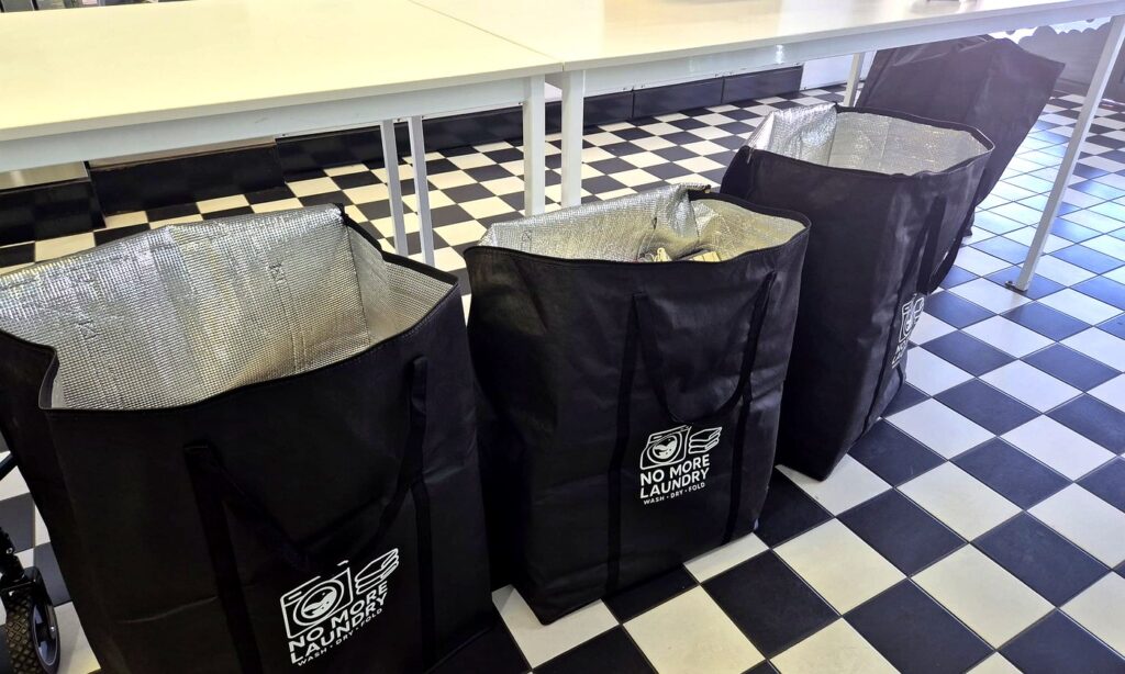 Laundry bags at Melbourne laundromat ready for wash dry fold service